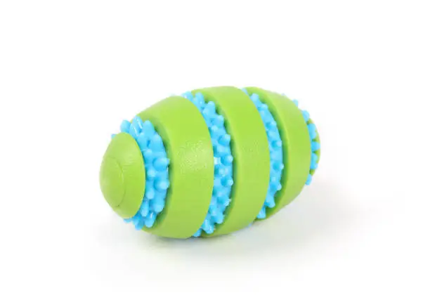 Isolated rubber dog toy with textured nubs to massage teeth and gums. Durable fun dog toy for throwing and playing and enrichment. Selective focus.