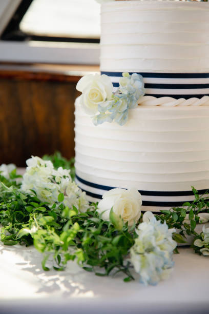 istock White wedding cake with blue hydrangea and roses decoration, Two tiered marine themed desert. 1464916395