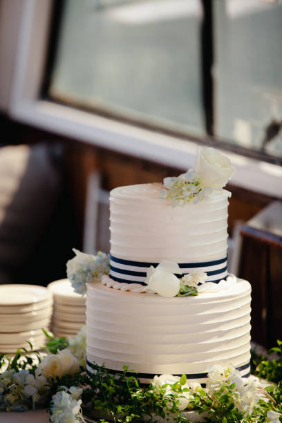 White wedding cake with blue hydrangea and roses decoration, Two tiered marine themed desert.