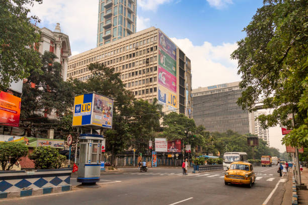 yellow taxi on city road with view of office buildings at sunrise near park street at kolkata - sunrise city of sunrise street road imagens e fotografias de stock