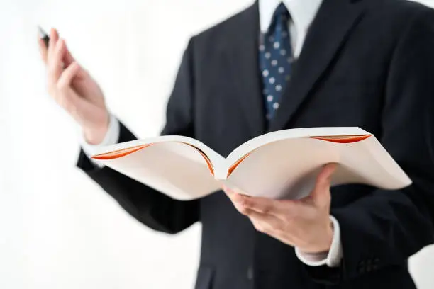 A school teacher explaining with a reference book