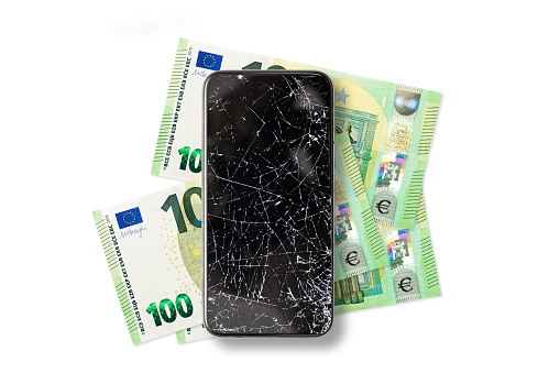 Black broken touch screen phone and 100 euros banknotes