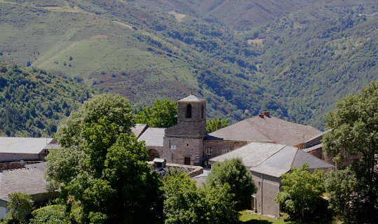 Small village in a green mountain countryside. Slate rooftops, church bell tower,  forest, view from above. Lugo province, O Courel, Galicia, Spain.
