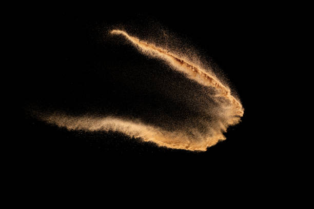 istock Dry river sand explosion. Brown color sand splash against black background. Yellow sand fly wave in the air. 1464926593