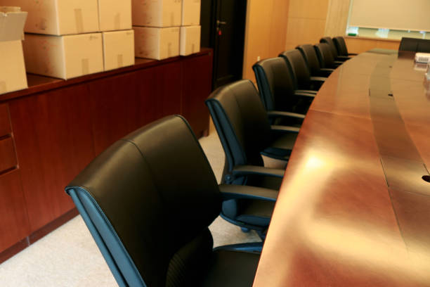 Empty white chairs surrounding modern table in a conference room, ready for a business meeting