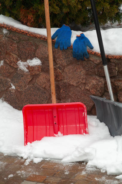istock Two plastic snow shovels stand in front of  fence 1464932045