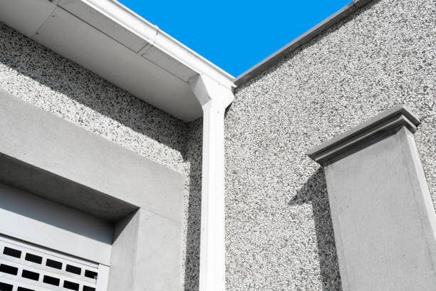 istock White gutter on the rooftop of house wall rain metal. White plastic rain guttering system. Guttering drainage pipe exterior. 1464932707