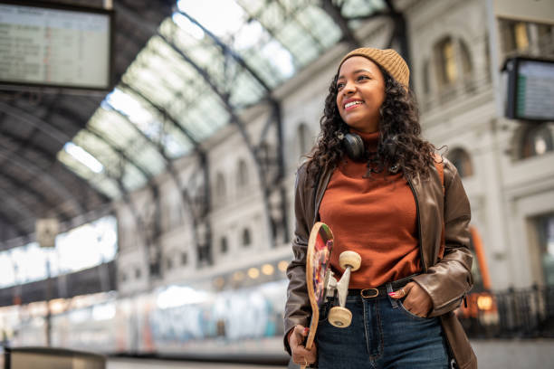 A young Spanish woman, black-skinned, is waiting for transportation at the subway station stock photo