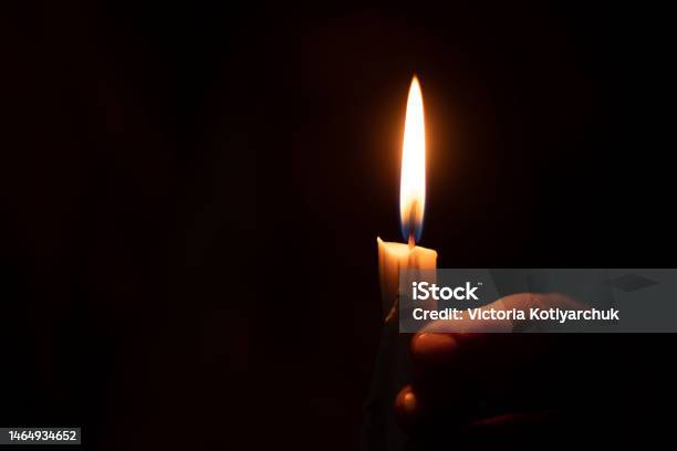 Candle Flame Illuminates A Female Hand In A Dark Room Stock Photo - Download Image Now