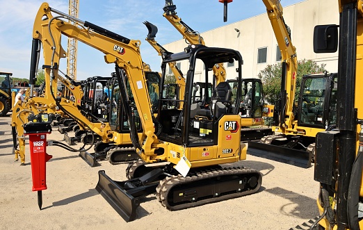 Pavia di Udine, Italy. September 3, 2022. Brand new Caterpillar CAT mini excavators on exhibition outside the official dealer.\tSide view.