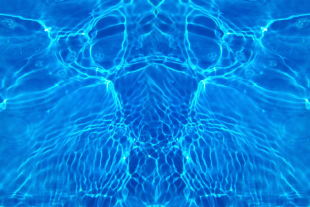 Defocus blurred transparent blue colored clear calm water surface texture with splashes and bubbles. Trendy abstract nature background. Water waves in sunlight with copy space. Blue watercolor shining
