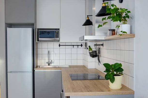 istock Modern stylish Scandinavian kitchen interior with kitchen accessories. Bright white and grey kitchen with household items in studio apartment 1464939505