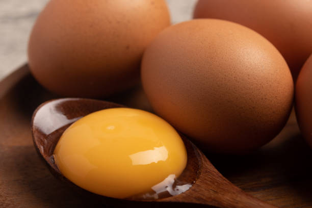 istock Fresh chicken eggs in a wooden plate 1464941323