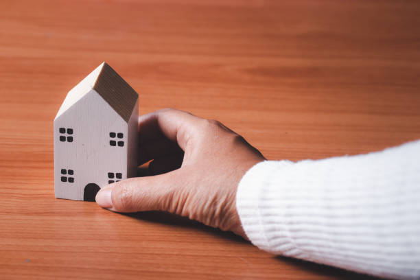 istock Woman's hand with a small house in hand, vintage style. 1464941574