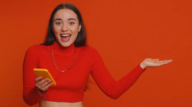 istock Girl using smartphone pointing empty place, positive feedback recommends social networks application 1464942983