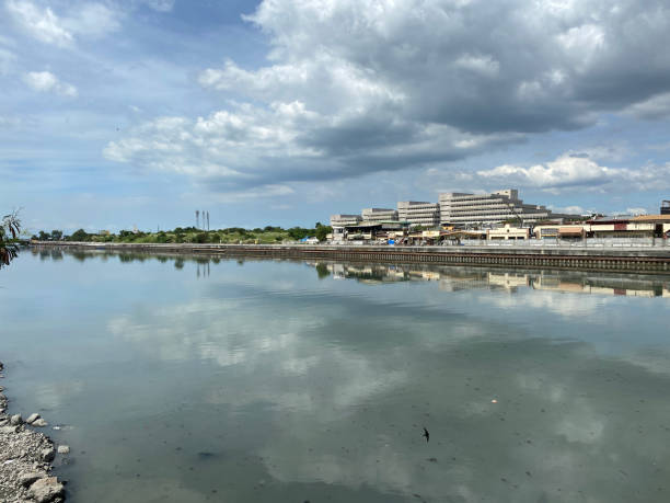 istock High-rise tenement buildings reflected on a huge and murky river under thick dark clouds. 1464945217