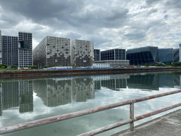 istock High-rise tenement buildings reflected on a huge and murky river under thick dark clouds. 1464945235