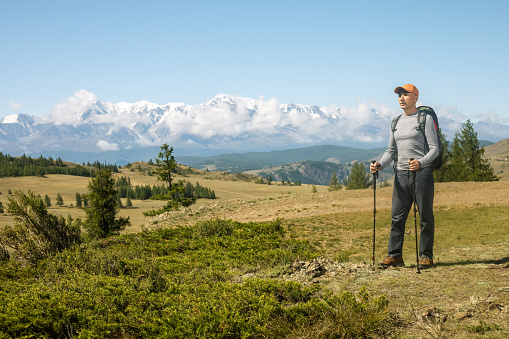 Active mature man hiking on sunny day in mountains. Travel lifestyle concept adventure active vacations outdoor.