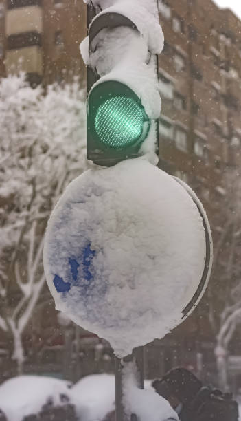 istock Green traffic light and traffic signal covered by a big snowfall 1464951002