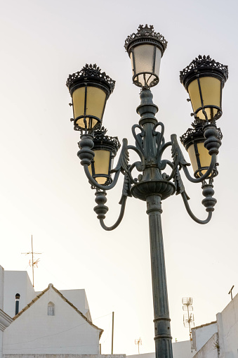 A low-angle shot of old-styled street lamps against the white sky