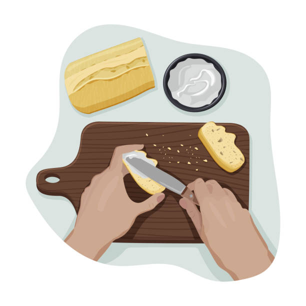 Hands spread cream cheese on a bread with knife. Hands of young person spread cream chease on a crispy slice of bread with knife on a wooden cutting board with crumbs from personal point of view. Process of cooking. Vector flat isolated concept spreading cheese stock illustrations