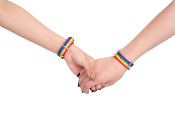 istock Clasped hands with LGBTQ flag bracelets on white background 1464953907