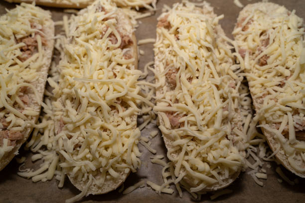 istock Unbaked tuna sandwich halves with cheese on the baking sheet 1464954669