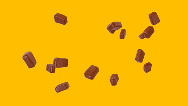 istock 3D rendering of chocolate pieces on a yellow background 1464956106