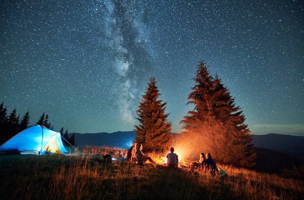 istock Night camping in mountains under starry sky with Milky way. 1464956232