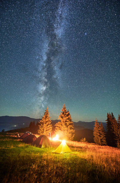 istock Night camping in mountains under starry sky with Milky way. 1464956390