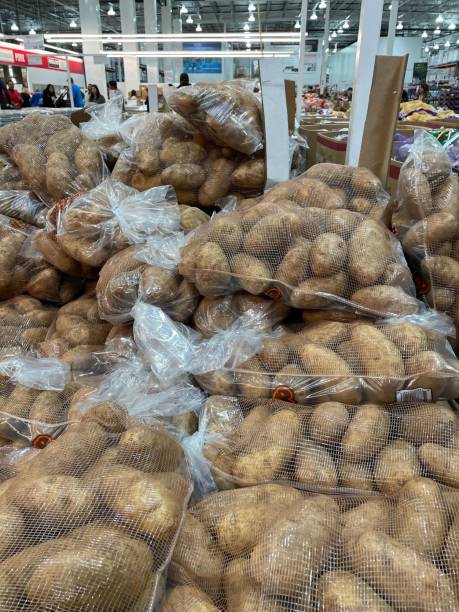 toma vertical de grandes bolsas de red de papas en la tienda costco en fresno - red potato raw potato market red fotografías e imágenes de stock