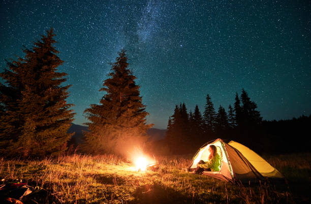 istock Night camping in mountains under starry sky with Milky way. 1464956534