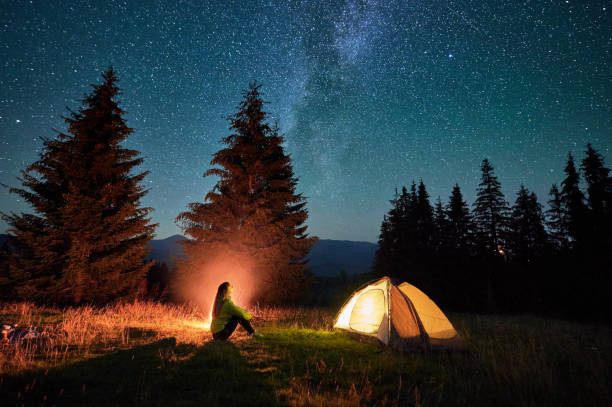 istock Night camping in mountains under starry sky with Milky way. 1464956636