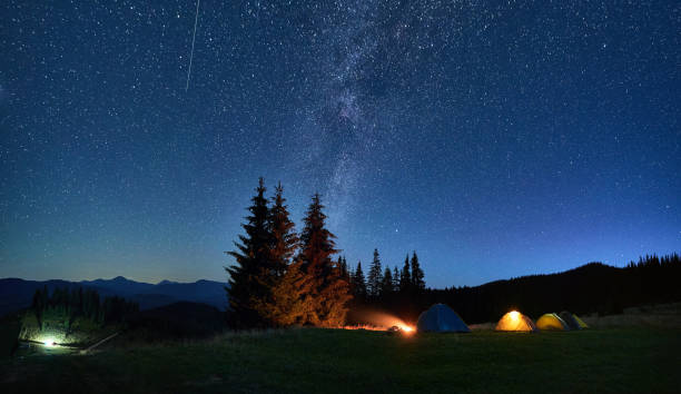 istock Night camping in mountains under starry sky with Milky way. 1464956685