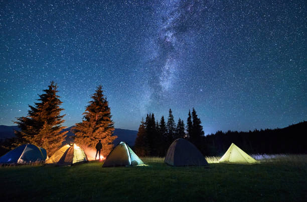 istock Night camping in mountains under starry sky with Milky way. 1464956718
