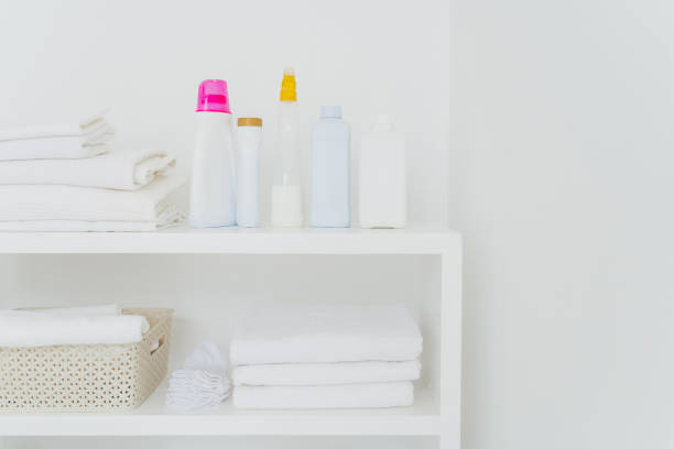 istock Stack of clean white towels with detergents on console isolated over white background. Fresh laundry and liquid washing in bathroom 1464956895