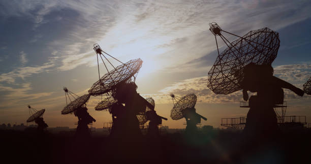 большие спутниковые антенны, направленные на небо в сумерках для научной концепции - moody sky audio стоковые фото и изображения