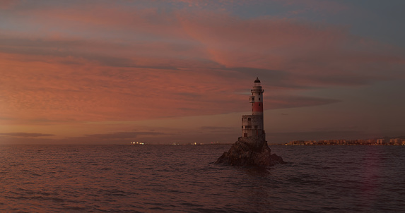 Romantic seascape with a lighthouse in open waters. Mysterious lighthouse