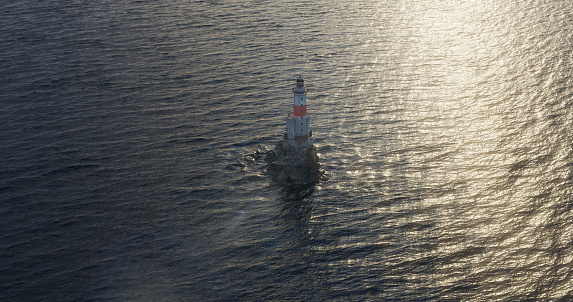 Romantic seascape with a lighthouse in open waters from the drone footage. Mysterious lighthouse