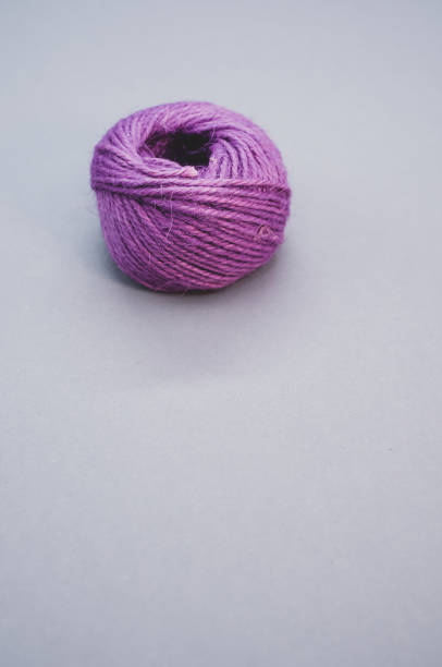 istock Vertical shot of a purple thread yarn isolated on a grey background 1464958413