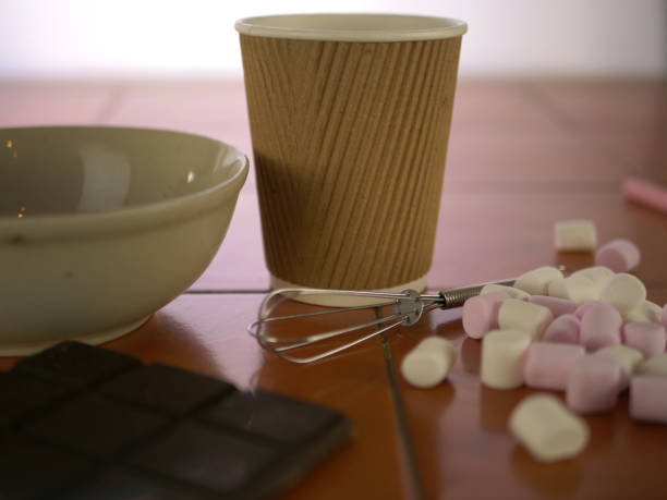 A plate of traditional chocolate-covered “Flødeboller” cakes. They consist of a thin, baked marzipan base with a marshmallow filling that is then dipped in chocolate and can be topped with coconut, pistachio nuts, dried flakes of fruit or anything you want really! Here the baker is adding a dusting of edible gold powder to make them extra special on your Christmas table.