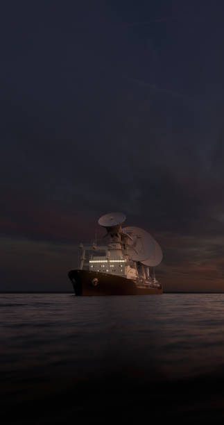 Scientific ship with radio antennas sailing in open waters at night from the front side