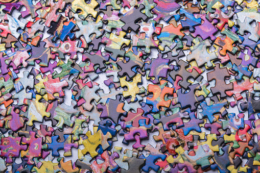 A lot of scrambled puzzle pieces. Abstract background of scattered puzzle pieces. Textured background made with jumbled pieces of a puzzle game.