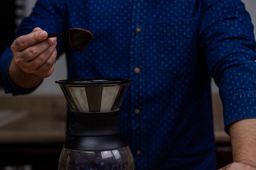A closeup shot of a Hispanic man making a coffee