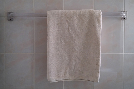 White bath towel for shower on the towel holder.