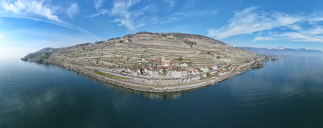 A majestic panoramic aerial view of the waterfront Saint-Saphorin village with rural buildings in Lavaux, Switzerland