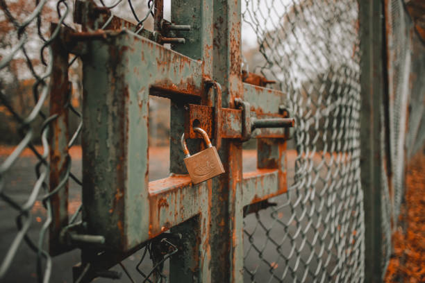 istock Selective focus shot of a rusty iron fence with a padlock 1464961477