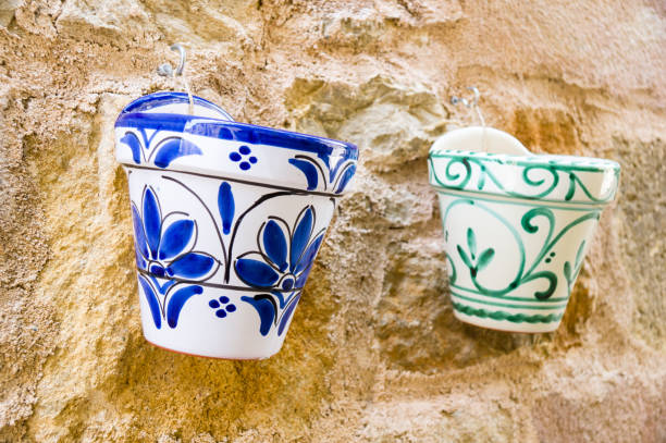 A selective focus shot of pots hanging on a weathered wall