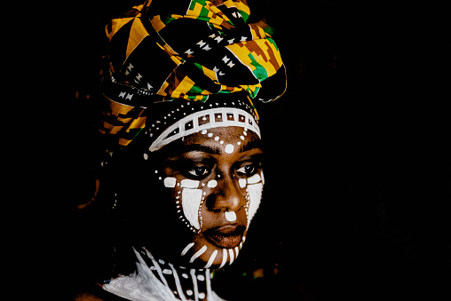 Mujer africana en retrato con pintura facial y tocado. photo