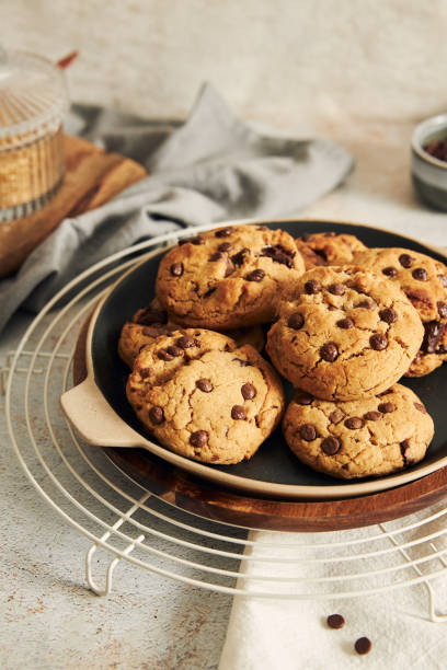 istock Plate with deliciously baked cookies with chocolate chips on a baking grid 1464961608